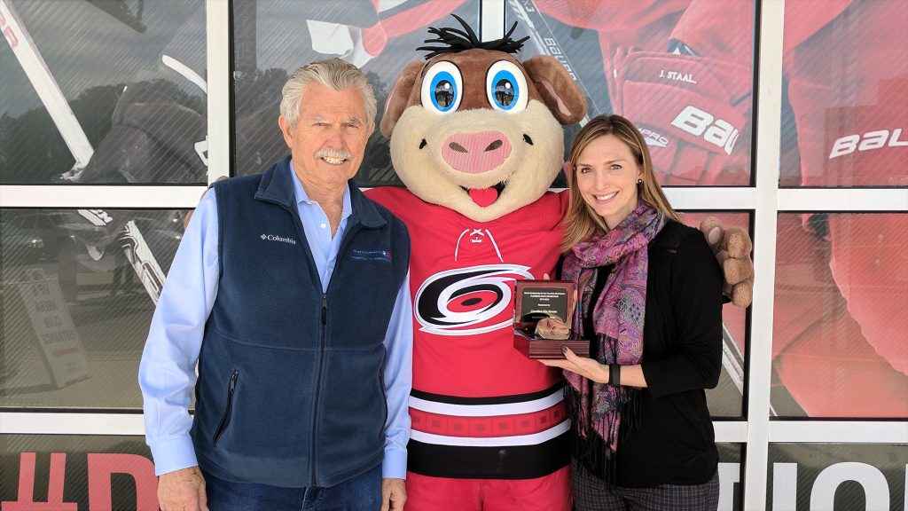 Lou and Amber Moshakos, Owner & President of LM Restaurants in Raleigh, NC. Standing with Stormy, mascot for the Carolina Hurricanes hockey team.